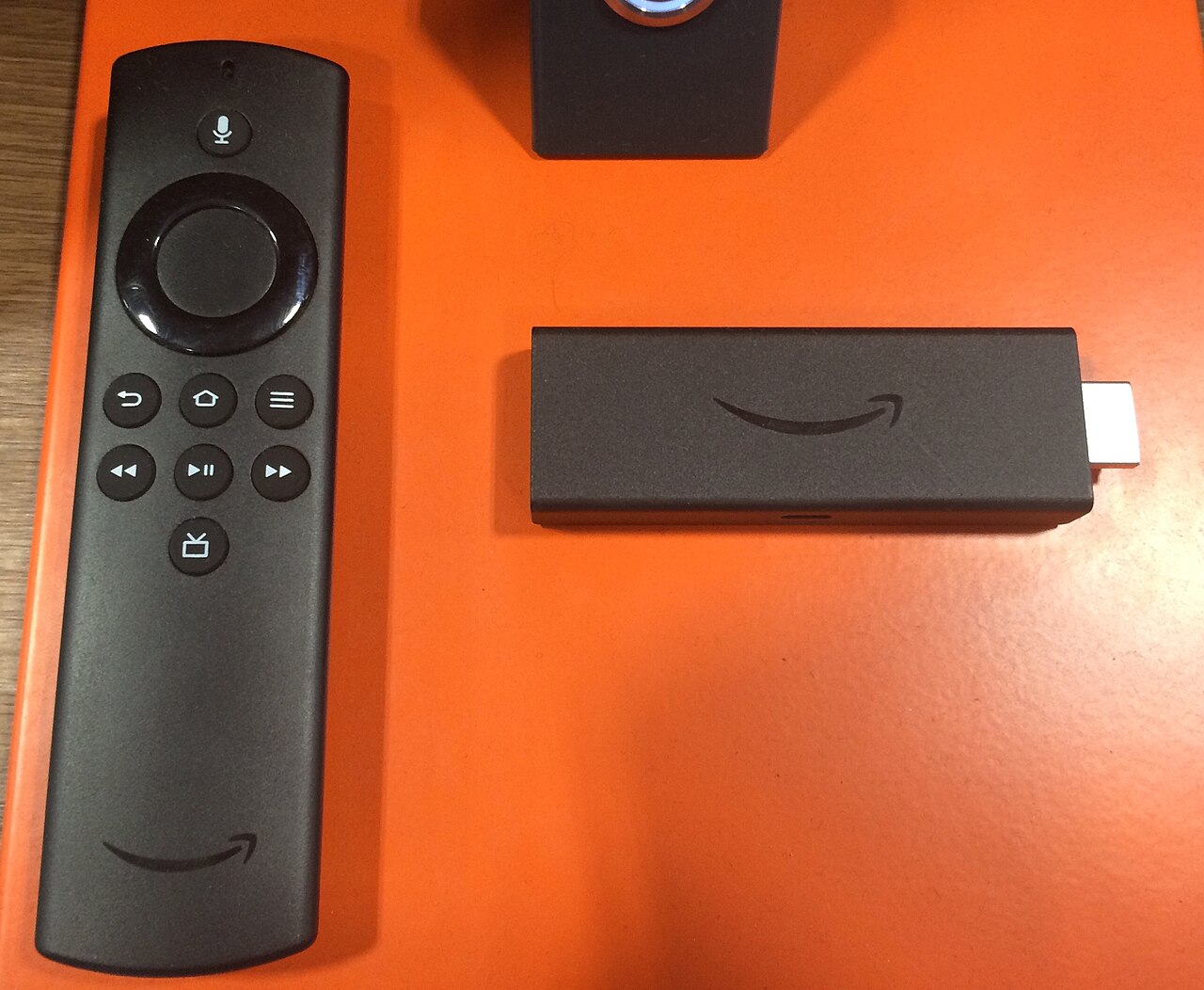 An Amazon Fire TV Stick and its remote on display — another model in the line, not the 4K Plus in this deal