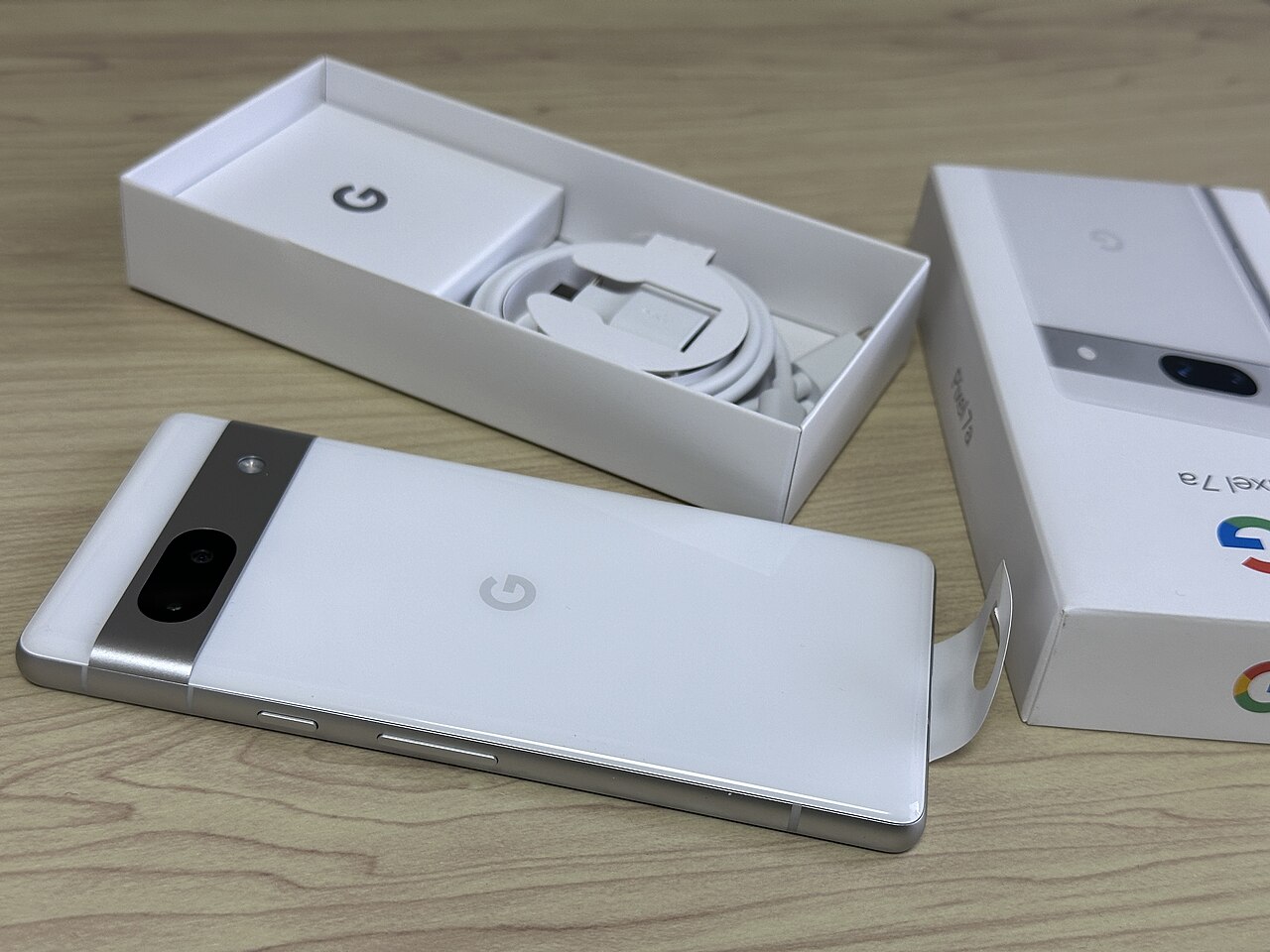 A previous-generation Google Pixel A-Series phone shown unboxed next to its retail box